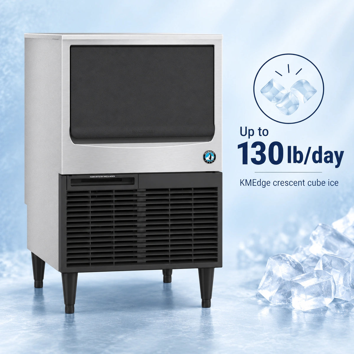 A commercial ice machine with a stainless steel upper section and black lower grille, shown on a icy blue background with ice cubes and text reading 'Up to 130 lb/day' and 'KMEdge crescent cube ice.'.