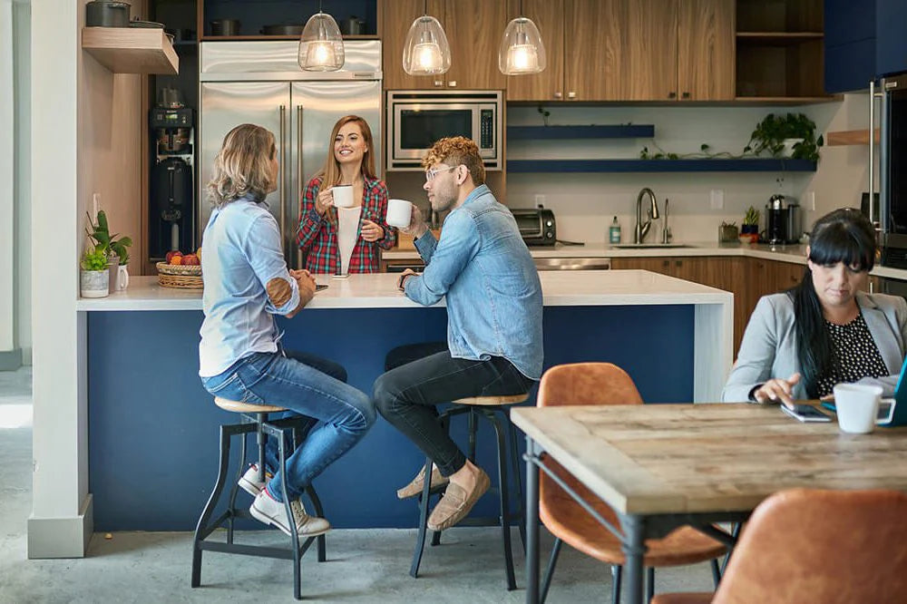 Group of people socializing in a modern kitchen.