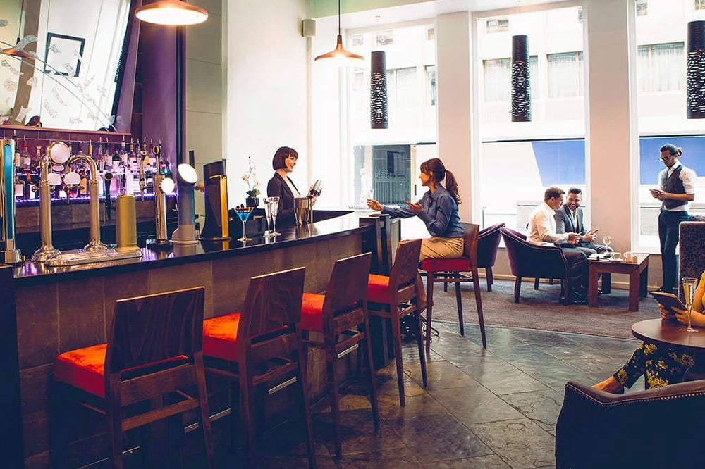 Bar area with patrons and staff in a modern interior setting