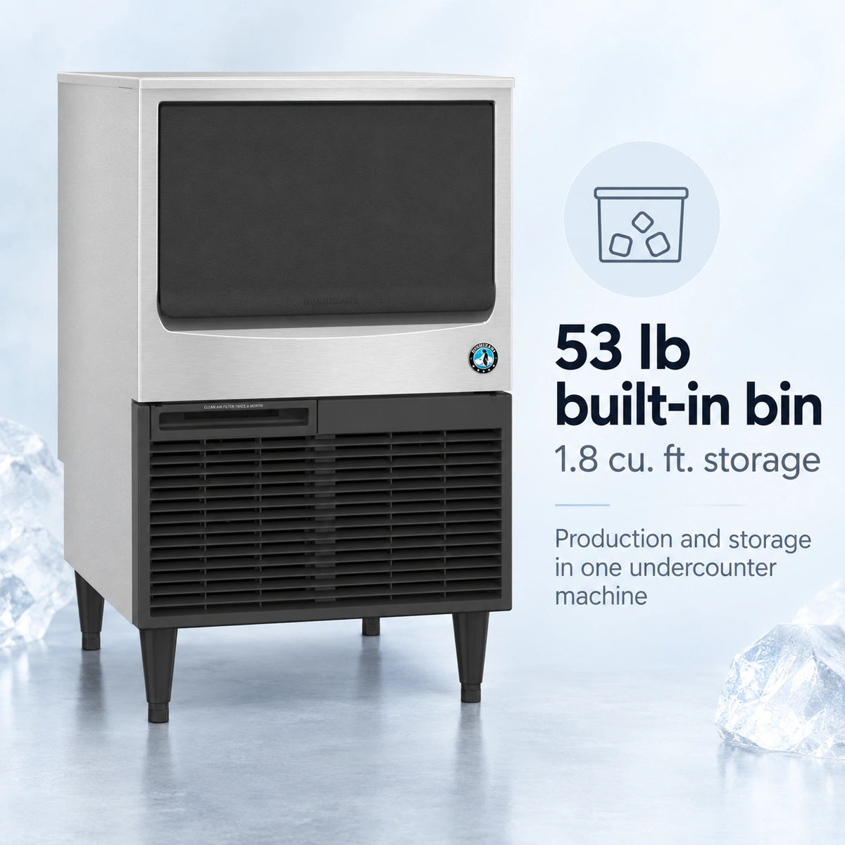 A commercial ice machine with a stainless steel upper cabinet and black lower section, shown on a light blue studio background with ice cubes and marketing text reading '53 lb built-in bin, 1.8 cu.
