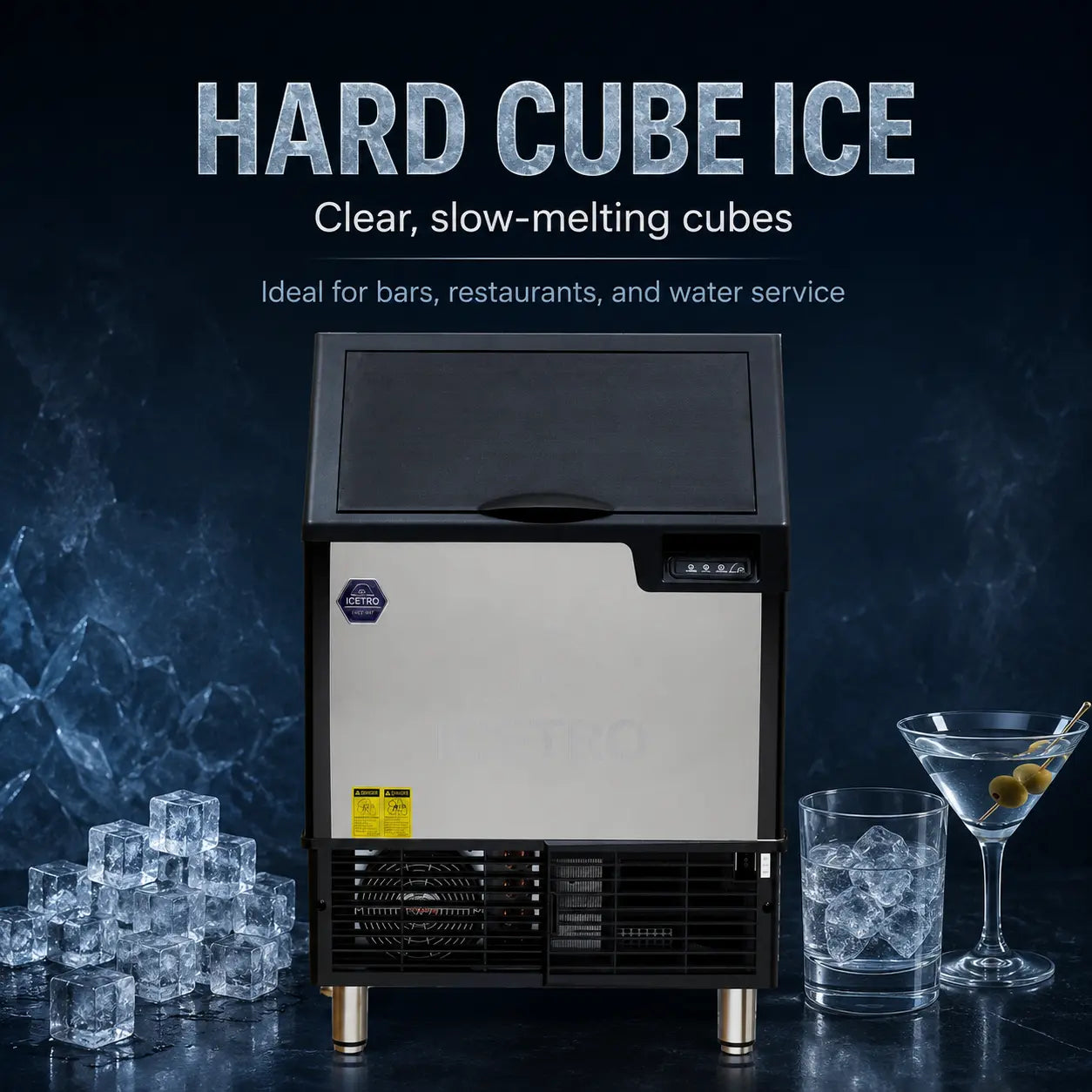 A countertop hard cube ice machine with a brushed silver front panel and black top, feet, and lower grille, shown on a dark blue promotional background with text reading 'HARD CUBE ICE' and ice cubes, a martini glass, and a glass of water around it.