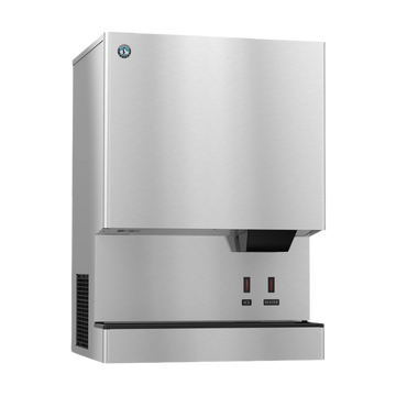 A stainless steel commercial ice machine with a brushed metal finish, featuring a black drip tray, two red power switches labeled ON and OFF, and a small circular blue logo badge near the top left corner.