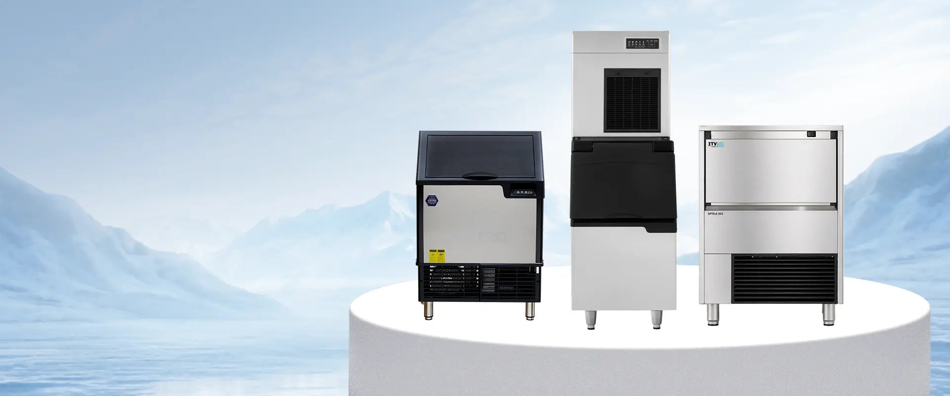 Three commercial ice machines in different sizes displayed side-by-side against a light blue sky and mountain background.slider_item_7tXBrF