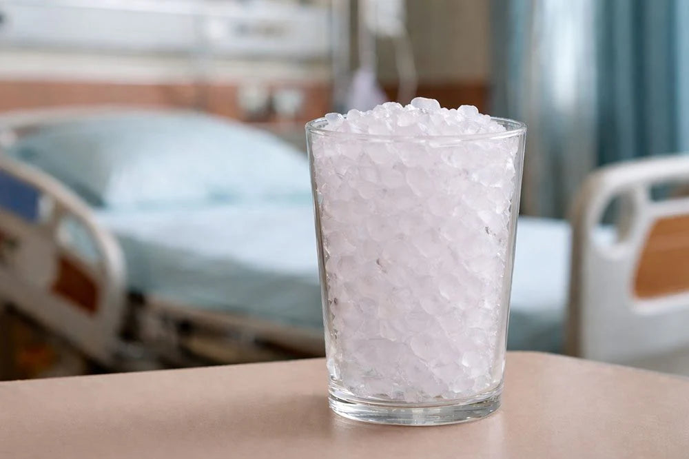 Glass of pink pearls on a hospital bed with blurred background