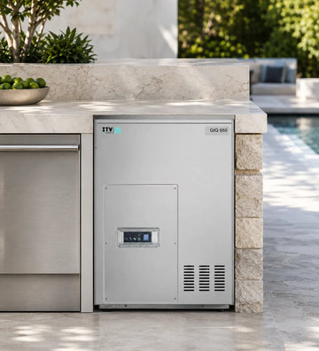 Outdoor kitchen refrigerator with 'ITV' branding on a stone countertop by a pool.