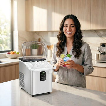 Woman in a kitchen holding a drink next to a portable ice maker.