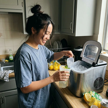 Person using an ice maker in a kitchen