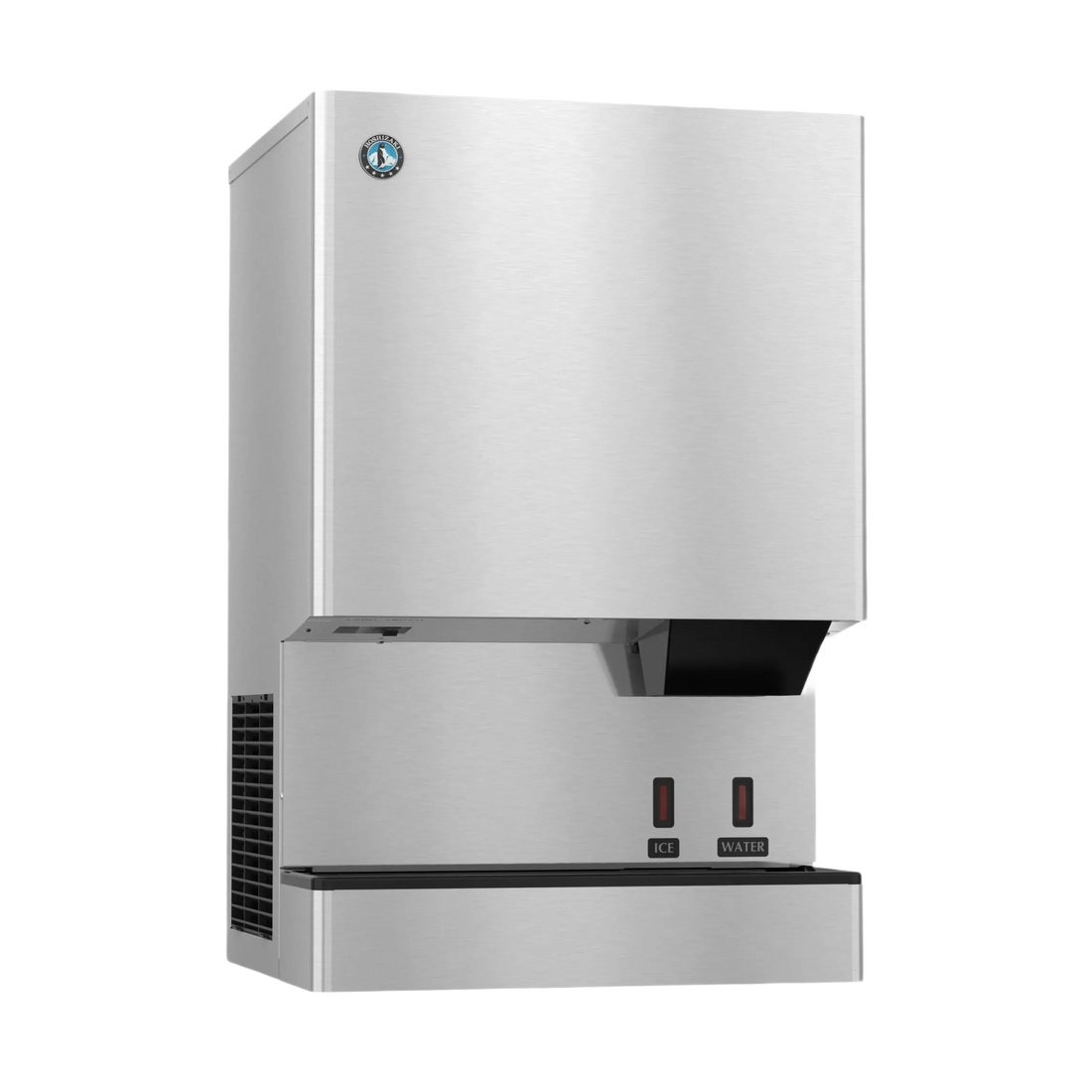 A stainless steel commercial ice machine with a brushed metal finish, featuring a black drip tray, two red power switches, and a small circular logo badge on the upper left front panel.