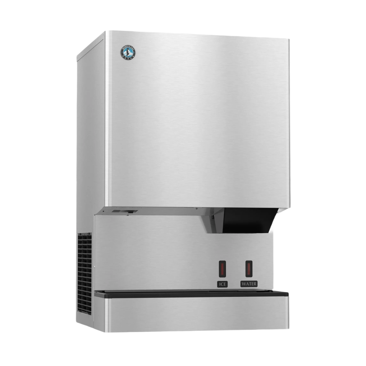 A stainless steel commercial ice machine with a brushed metal finish, featuring a black drip tray, two red power switches, and a small circular logo badge on the upper left front panel.