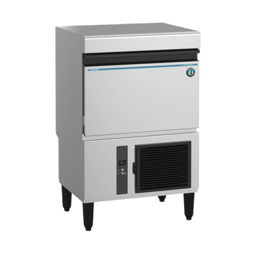 A commercial countertop ice machine with a stainless steel body, black legs, a black front grille, and a small blue brand label on the upper right front panel, shown on a plain white background.
